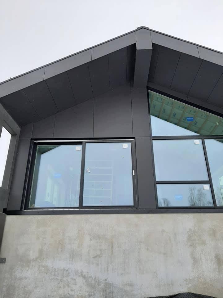 A gable with new dark cladding and tall windows
