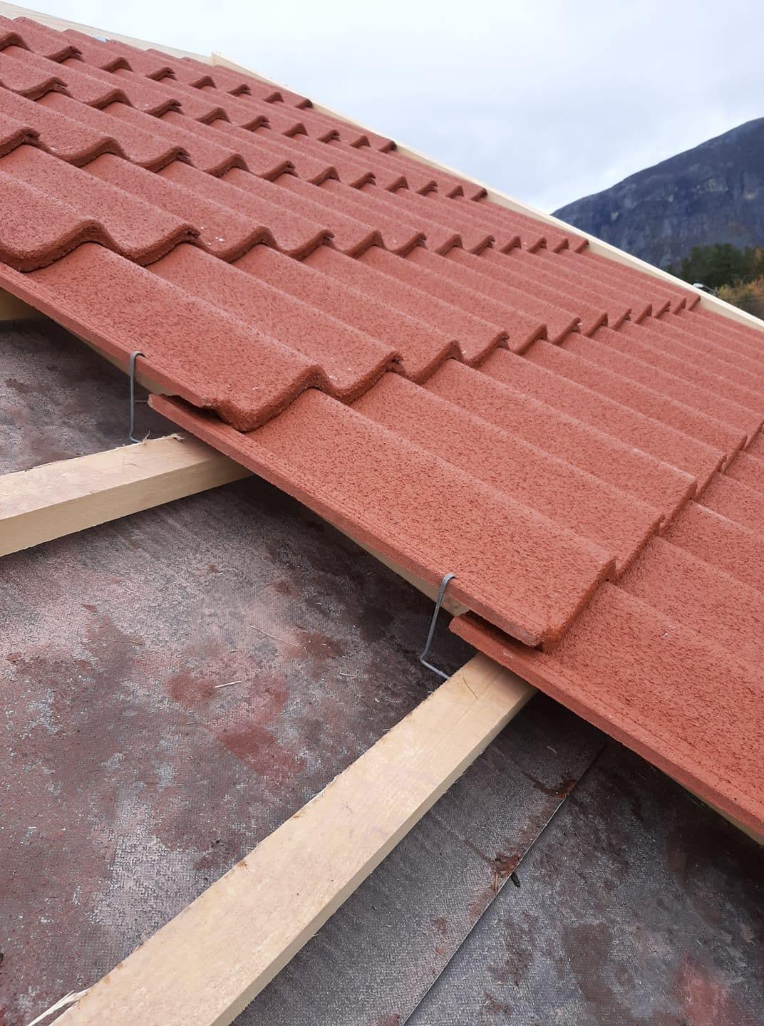 Red roof tiles being laid on battens